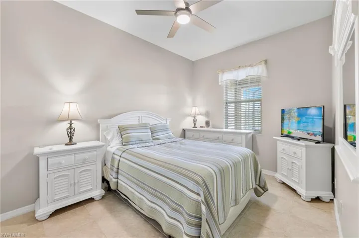 Tiled bedroom with ceiling fan, TV