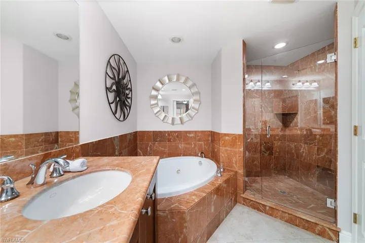 Bathroom featuring a bath, a shower stall, vanity, and light tile patterned floors