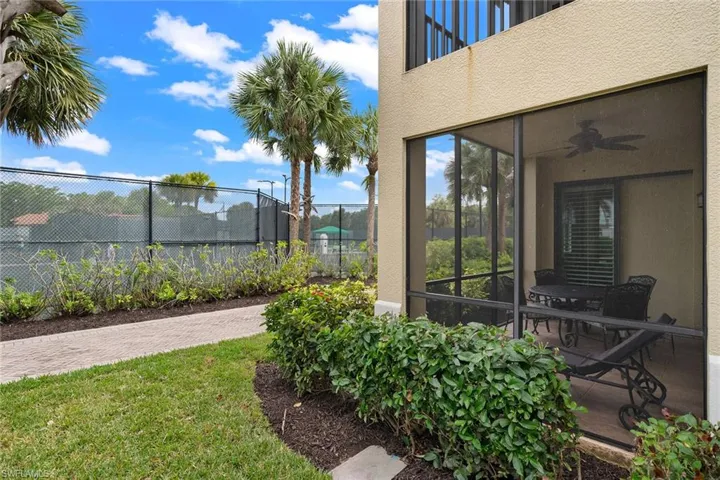 View of yard featuring a sunroom, a ceiling fan, and a balcony
