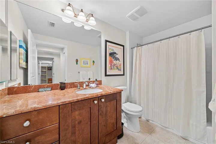 Bathroom featuring vanity, light tile patterned flooring, and shower / bath combination with curtain