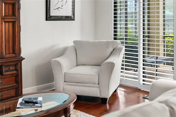 Sitting room with dark wood finished floors and baseboards