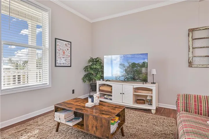 Living room featuring crown molding and dark wood finished floors