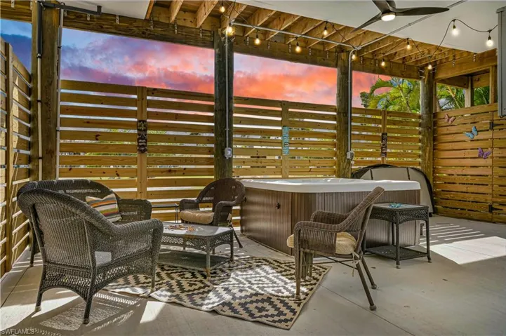 View of patio with a hot tub and a ceiling fan