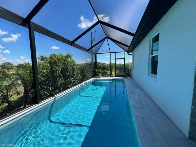 Swimming pool featuring a sunroom, a lanai, and a patio
