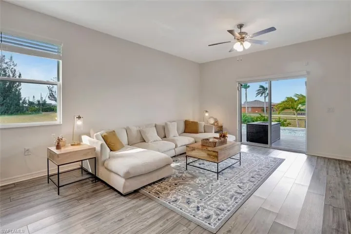 Living area with light wood-style flooring and a ceiling fan