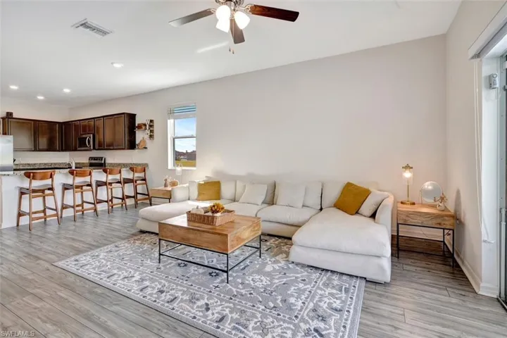 Living area featuring light wood finished floors, ceiling fan, and recessed lighting