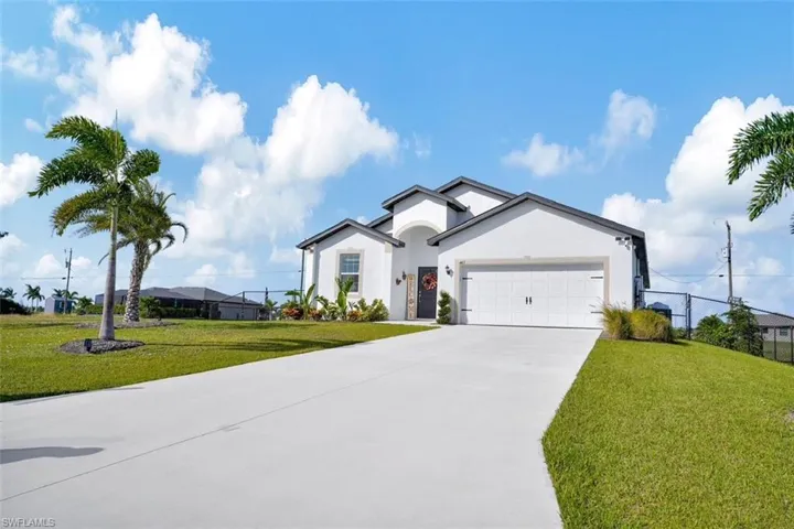 Single story home featuring stucco siding, concrete driveway, and an attached garage