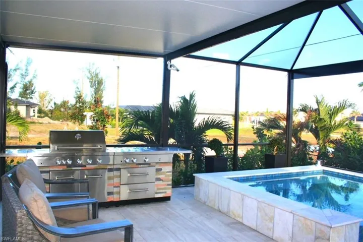 View of swimming pool featuring a lanai, exterior kitchen, a sunroom, a swimming pool, and a patio area