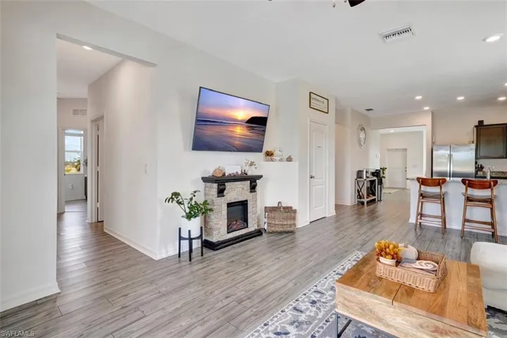 Living room featuring a fireplace, light wood-type flooring, and recessed lighting