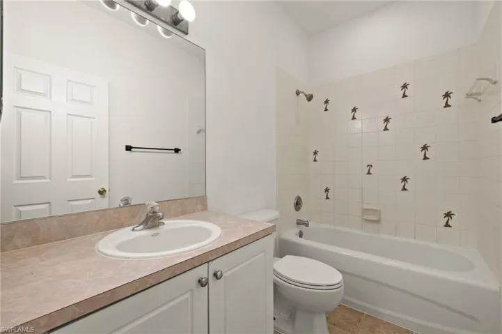 Bathroom featuring vanity, toilet, tile patterned flooring, and shower / bath combination