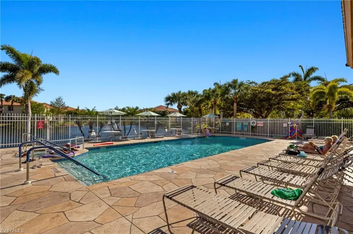 Community pool featuring a patio and fence