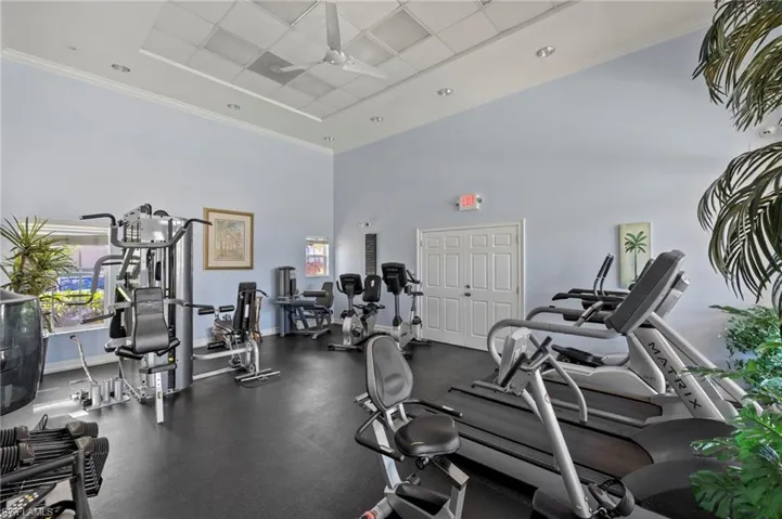 Exercise room featuring ornamental molding, a healthy amount of sunlight, baseboards, and ceiling fan