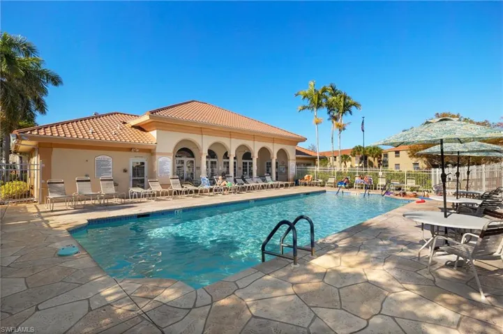 Community pool featuring a patio and fence