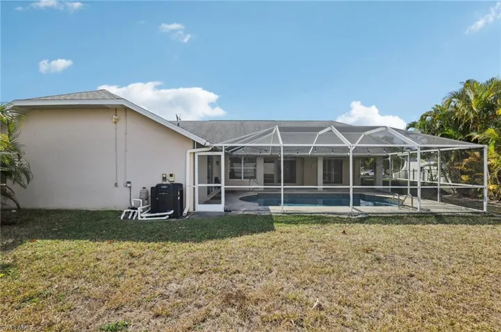 Rear view of house with an outdoor pool, a lanai, a patio, and a sunroom