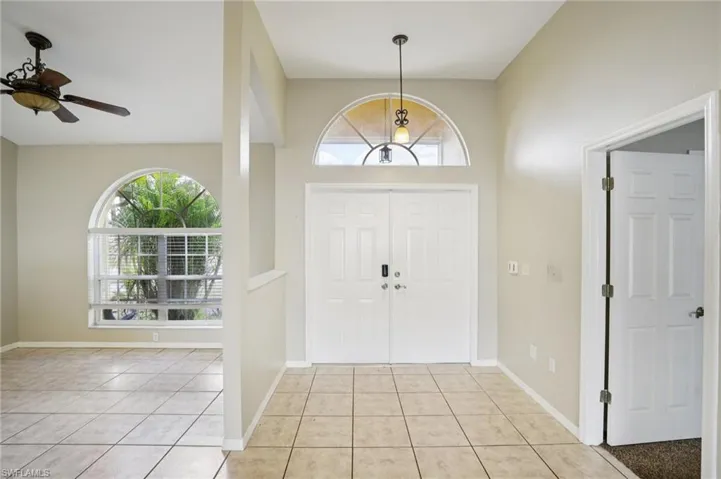 Foyer featuring light tile patterned flooring and ceiling fan