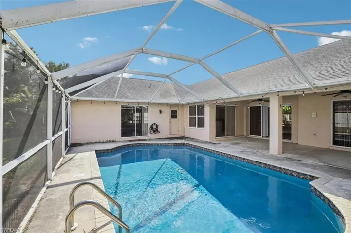 Outdoor pool featuring a patio, a sunroom, and a lanai