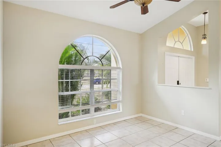 Empty room featuring ceiling fan and light tile patterned floors