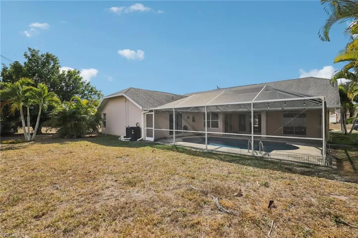 Back of house featuring an outdoor pool, a lanai, a patio, a sunroom, and stucco siding