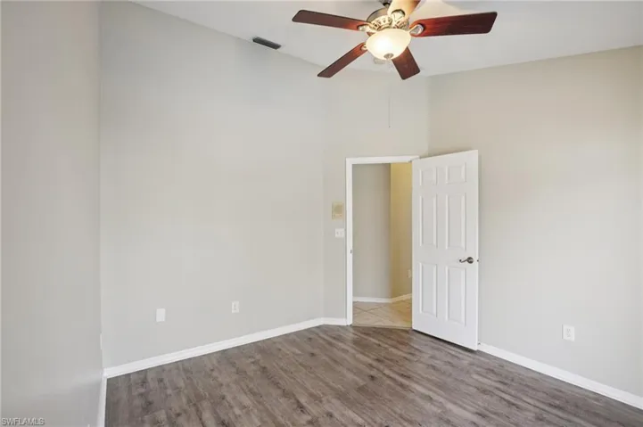 Empty room with wood finished floors and a ceiling fan