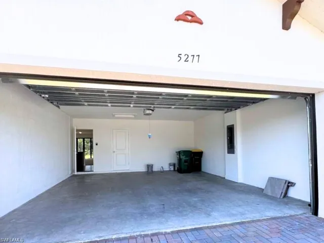 Two Car Garage featuring electric panel, access to HVAC system, and a garage door opener