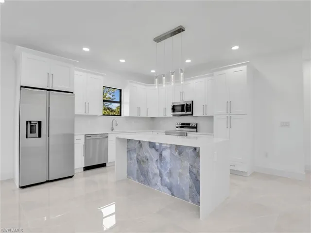 Kitchen featuring recessed lighting, white cabinets, stainless steel appliances, and light countertops