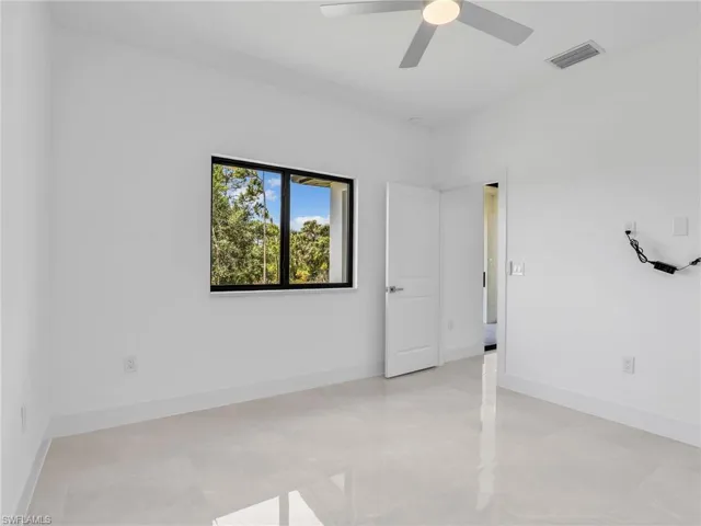 Spare room with visible vents, ceiling fan, and baseboards