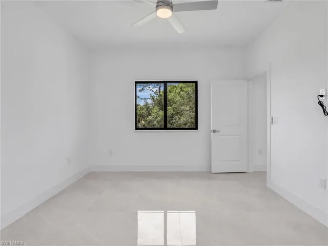Unfurnished room featuring baseboards and ceiling fan