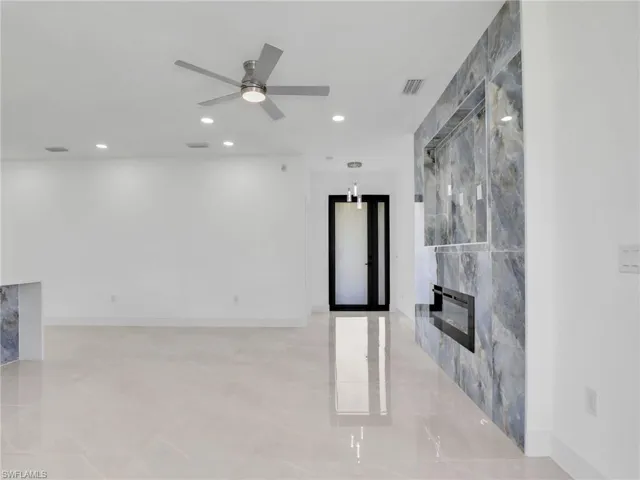 Unfurnished living room with a high end fireplace, recessed lighting, a ceiling fan, and visible vents