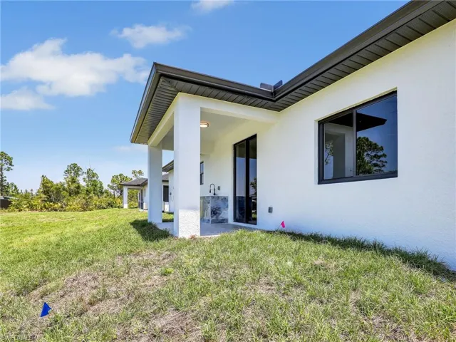 Back of property featuring stucco siding and a yard