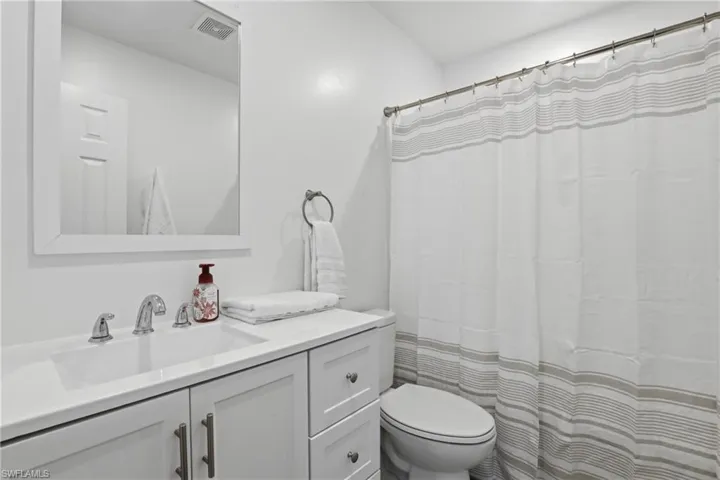 Bathroom featuring a shower with shower curtain and vanity
