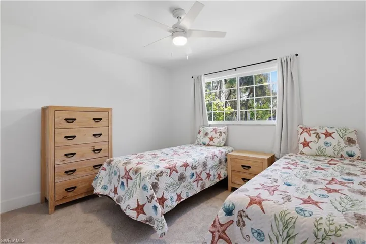 Bedroom with ceiling fan and light colored carpet