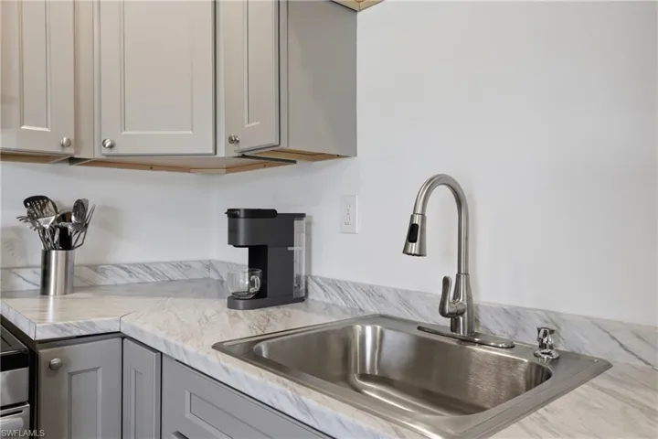 Kitchen with light countertops and gray cabinets