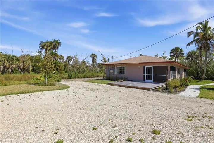Back of property featuring a patio area, a sunroom, and stucco siding