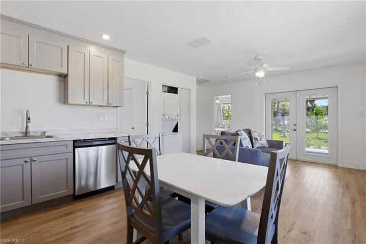 Dining area with stacked washer and dryer, french doors, light wood-style floors, a ceiling fan, and recessed lighting