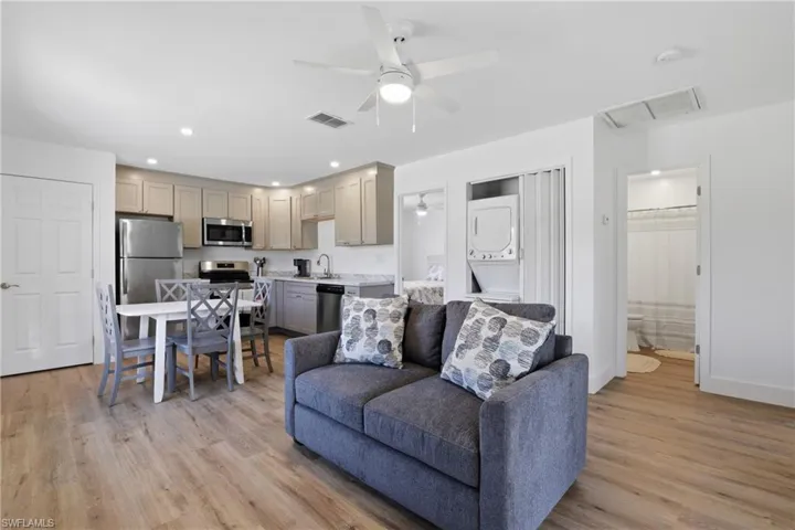 Living room featuring a ceiling fan, recessed lighting, stacked washer / dryer, and light wood-type flooring