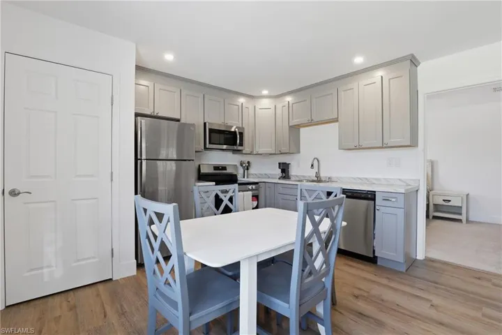 Kitchen with light countertops, stainless steel appliances, gray cabinets, light wood-style flooring, and recessed lighting