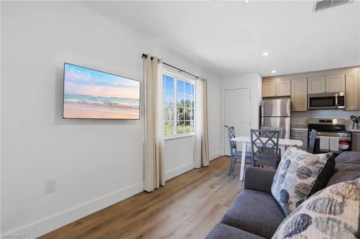 Living area with light wood-style flooring and recessed lighting