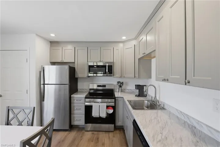 Kitchen featuring stainless steel appliances, gray cabinetry, recessed lighting, and light wood-type flooring