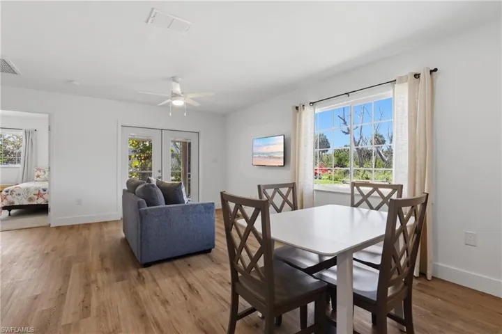 Dining room with french doors, light wood finished floors, and ceiling fan