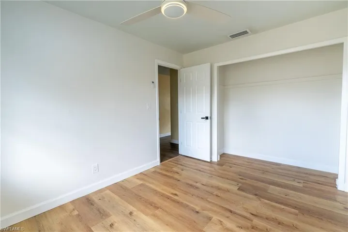 Unfurnished bedroom featuring light wood-style flooring, ceiling fan, and a closet