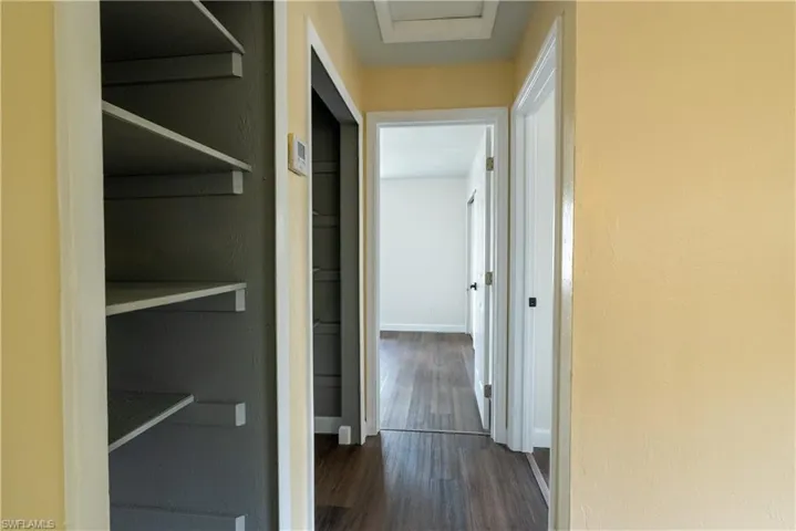 Hall featuring dark wood-style flooring and attic access