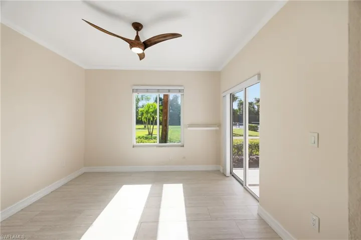 Guest bedroom featuring crown molding, ceiling fan and access to screened-in lanai