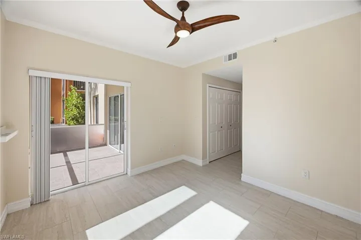 Guest bedroom featuring crown molding, ceiling fan and access to screened-in lanai