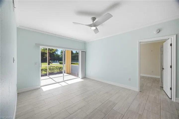 Living room featuring crown molding, ceiling fan, and tile floors