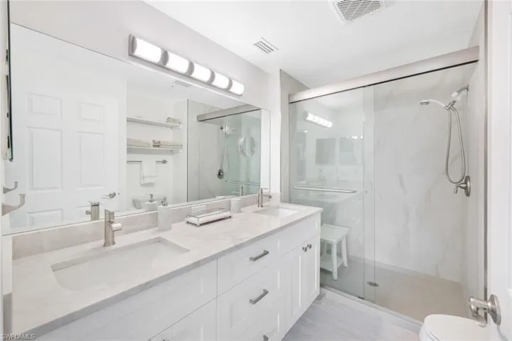 Primary bathroom featuring walk in shower, vanity, and toilet