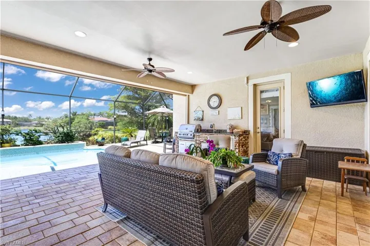 View of patio / terrace with a ceiling fan, an outdoor kitchen, an outdoor hangout area, and an outdoor pool
