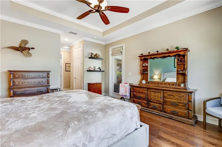 Bedroom with wood-type flooring, ornamental molding, recessed lighting, a ceiling fan, and baseboards