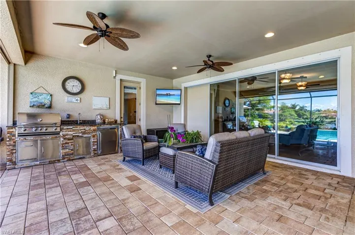 View of patio / terrace featuring a ceiling fan, exterior kitchen, grilling area, and a sink