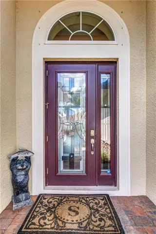 Doorway to property featuring stucco siding