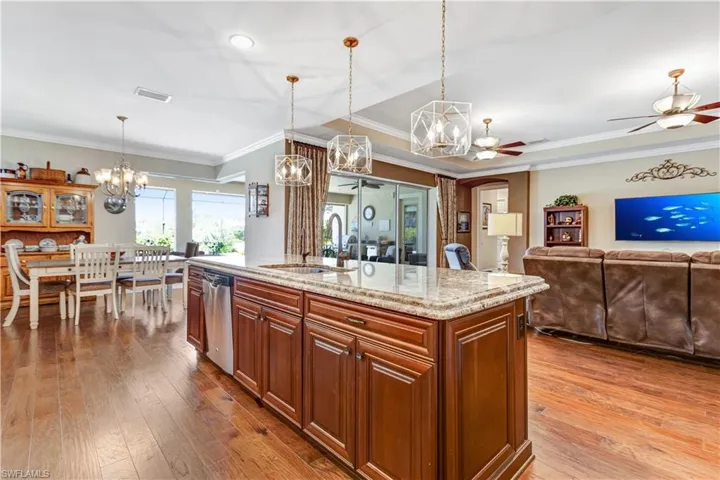 Kitchen featuring a sink, a chandelier, dishwasher, ceiling fan, and hardwood / wood-style flooring